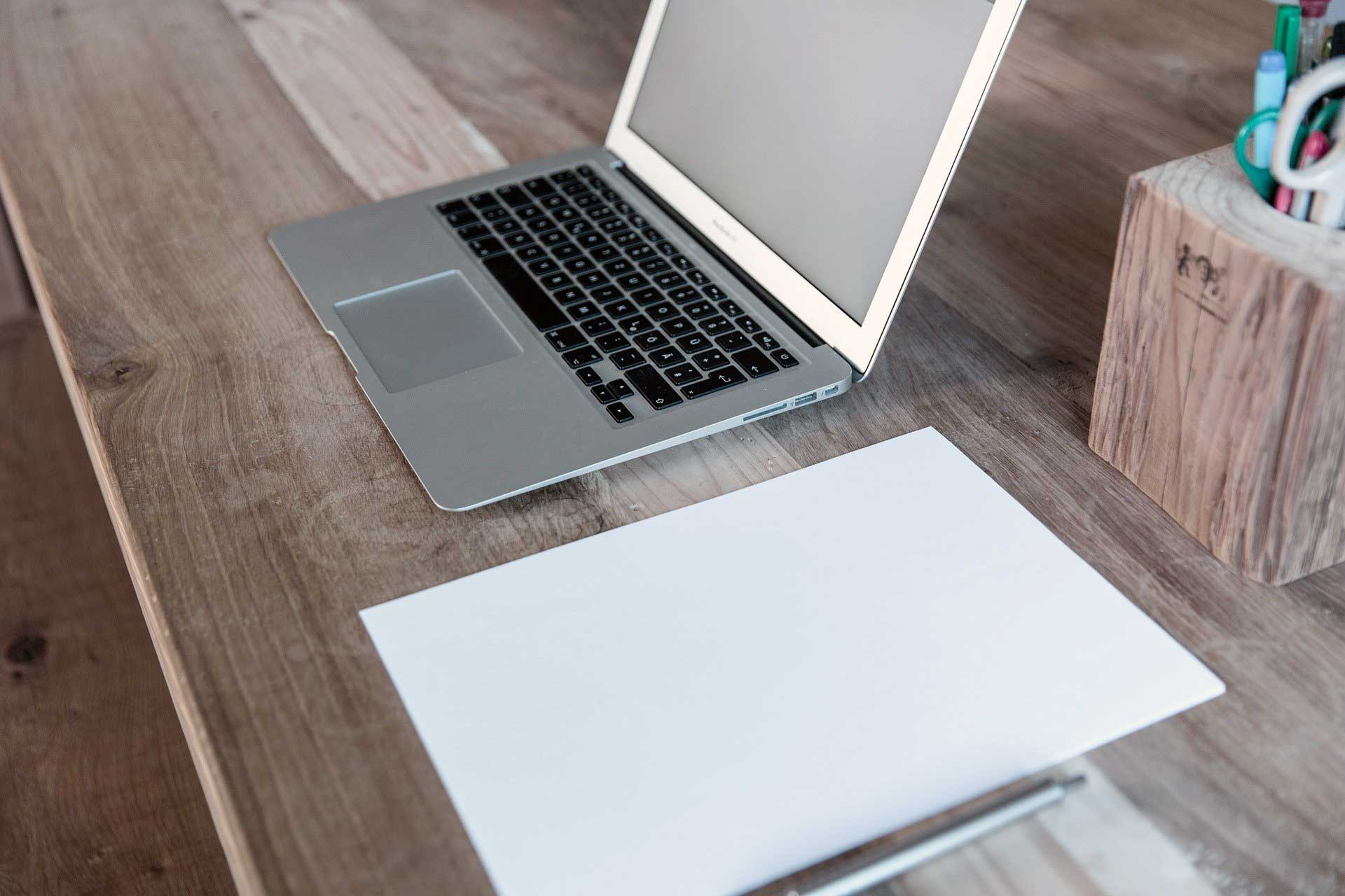 Masa uzerinde laptop ve kagit-kalem
